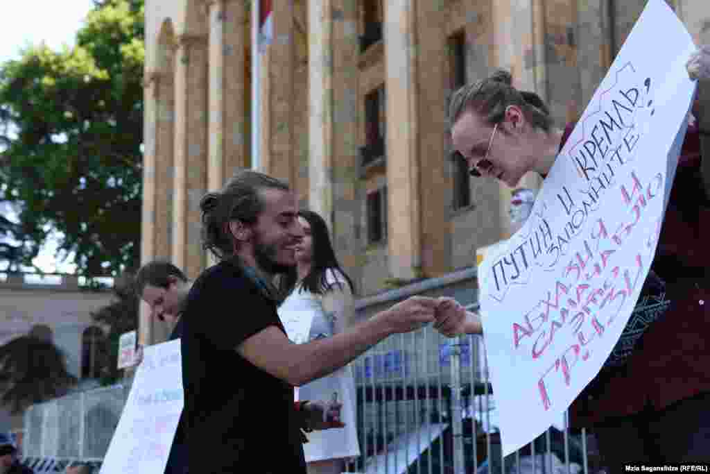 პარლამენტის წინ შეკრებილ რუს დემონსტრანტებს აქცია &quot;სირცხვილიას&quot; ორგანიზატორი ზუკა ბერძენიშვილი გამოელაპარაკა და სტიკერები უსახსოვრა.