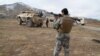  An Afghan security officer holding a rocket-propelled grenade stands at the sire of a deadly attack on an army base in Ghazni Povince on November 29.