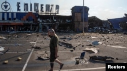 Un bărbat trece pe lângă un centru comercial lovit de un atac rusesc în orașul Kameanske din regiunea ucraineană Dnipropetrovsk, pe 26 iulie.