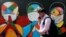 Egy járókelő maszkot viselő embereket ábrázoló grafiti előtt sétál el Indiában, Navi Mumbai városában 2021. január 21-én. 