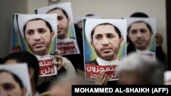 Bahrainis hold placards bearing the portrait of Sheikh Ali Salman, head of the Shiite opposition movement Al-Wefaq, during a protest on May 29, 2016 against his arrest, at Al Wefaq headquarter building.