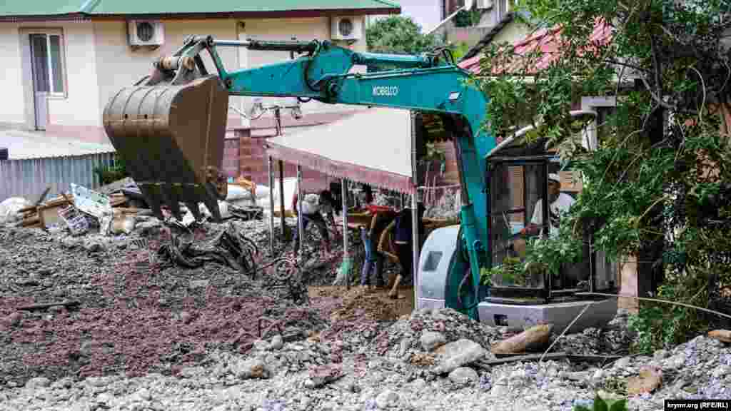 Yerli sakinler ev ve topraq damartılarını temizlemek içün öz parasınen ekskavatornı çağırdı