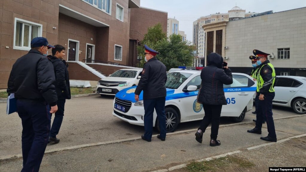 Полицейские забирают Байболата Кунболатулы и Гаухар Курманалиеву. Нур-Султан, 1 октября 2021 года