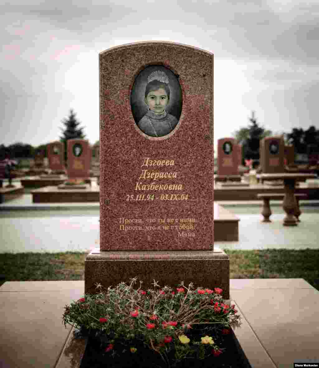 The grave of Kristina&#39;s sister, Dzera, stands with those of other Beslan victims in the cemetery that locals now call the &quot;Little Town of Angels.&quot; The cemetery is almost never empty. For many survivors, it&#39;s become a place to seek calm and carry out symbolic rites of passage for the children who never lived to adulthood. This year, many parents adorned gravestones with graduation ribbons for children who would have finished high school in 2014. Kristina says she still goes to the cemetery during trips home to talk to Dzera; it makes her feel happy.&nbsp;Kristina&#39;s mother remains deeply scarred by the loss of her younger daughter. The inscription on Dzera&#39;s gravestone reads, &quot;Forgive us that you&#39;re not here with us, and forgive me that I&#39;m not there with you -- Mama.&quot;