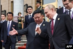 Russian President Vladimir Putin and North Korea's leader Kim Jong Un leave after their meeting in Beijing on September 3.