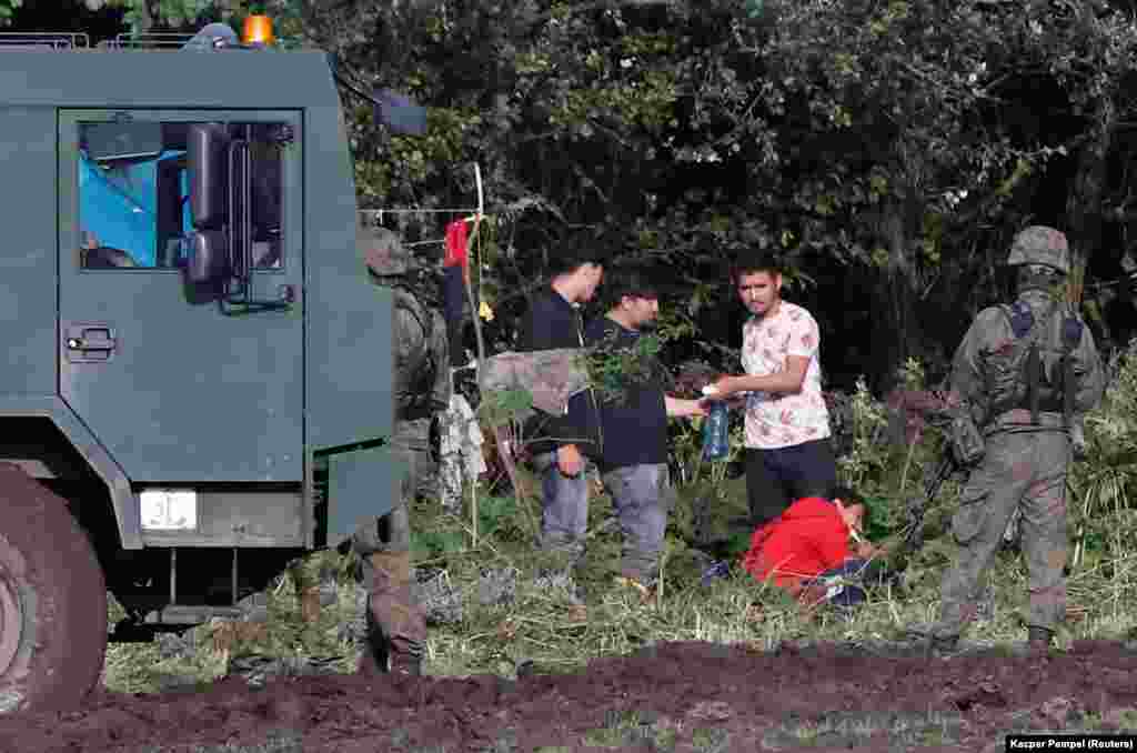 Bevándorlók csoportja katonák őrizetében a lengyel&ndash;belarusz határon szeptember 1-jén