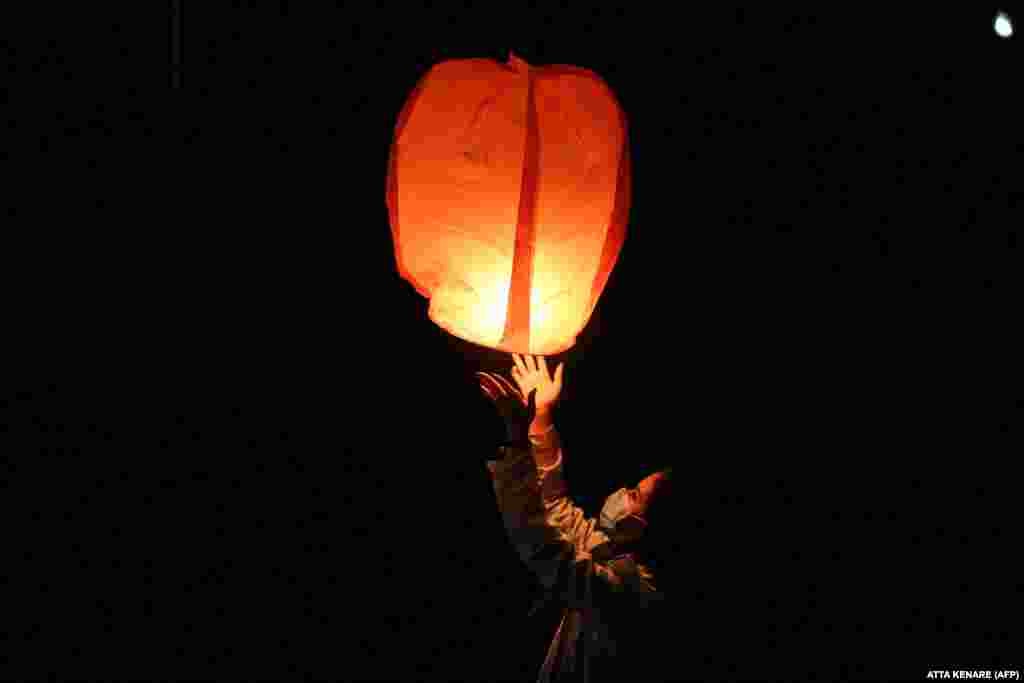 An Iranian releases a lantern in Tehran on March 16 during the Wednesday Fire feast, or Chaharshanbeh Soori, held annually on the last Wednesday eve before the spring holiday of Norouz. (AFP/Atta Kenare)