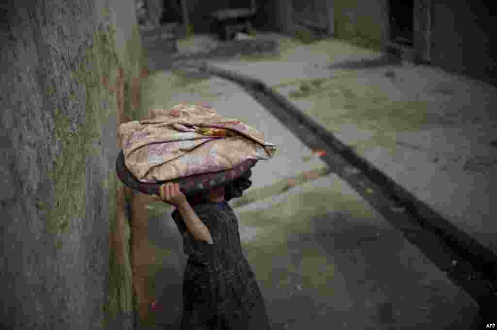 An Afghan child carries bread through the old quarters of Kabul. (AFP/Johannes Eisele)