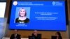 The winner of the 2023 Prize in Economic Sciences in Memory of Alfred Nobel American economist Claudia Goldin is seen on a display as (L-R) the chair of the Committee for the Prize in Economic Sciences in Memory of Alfred Nobel, Jakob Svensson, the Secret