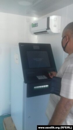 Мужчина безуспешно пытается снять деньги в одном из банкоматов в центре города Андижана.