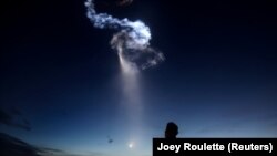 SpaceX компаниясы жасаған Falcon 9 зымыранының ғарышқа ұшқан сәтін бақылап тұрған адам. Канаверал мүйісі, Флорида, АҚШ, 29 маусым 2018 жыл.