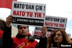 Oamenii țin pancarte pe care scrie „Ieșiți din NATO! Distrugeți NATO!”, în timpul unei manifestații împotriva războiului organizate în apropierea Ambasadei SUA, pe fondul conflictului dintre SUA și Israel cu Iranul, la Ankara, Turcia, pe 4 aprilie 2026.