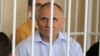 Belarus -- Former presidential candidate V Statkevich (C, first row) sits in a guarded cage during a court hearings in Minsk, 26May2011