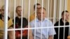 Belarus -- Former presidential candidate V Statkevich (C, first row) sits in a guarded cage during a court hearings in Minsk, 26May2011