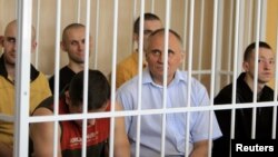 Belarus -- Former presidential candidate V Statkevich (C, first row) sits in a guarded cage during a court hearings in Minsk, 26May2011