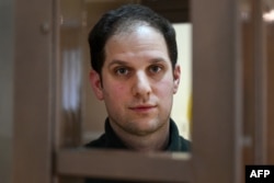 U.S. journalist Evan Gershkovich looks out from inside a defendants' cage before a hearing at the Moscow City Court on February 20.