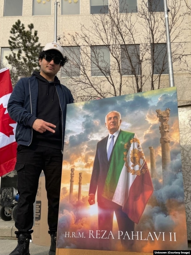 Milad Pourtalebian pozon me një portret të ish-Princit të Kurorës së Iranit, Reza Pahlavi, i cili aktualisht është në mërgim. Aktivisti beson se mbështetja e tij për Pahlavi ka çuar në kërcënime kundër tij.