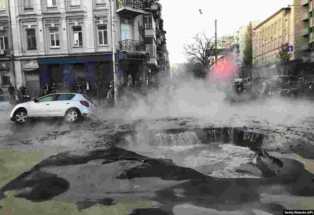 A car falls down in a hole caused by burst heating pipe in the center of the Ukrainian capital, Kyiv, on November 5. (AP/Sergey Ristenko)