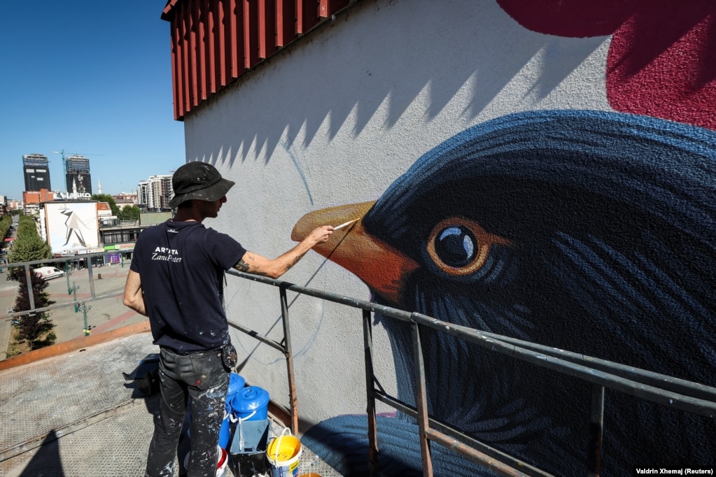 Artisti amerikan, Zane Prater, duke pikturuar një mural, më 19 shtator.