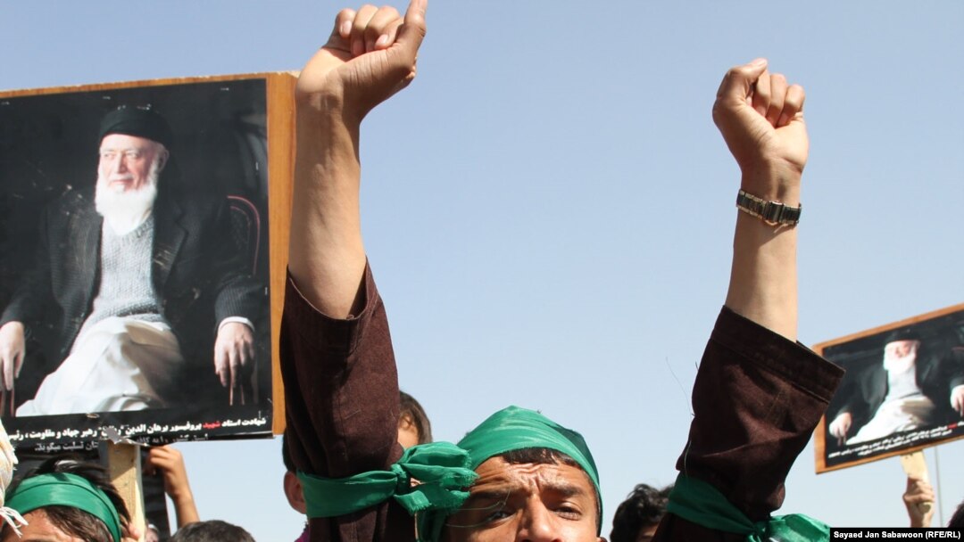 Supporters of slain former Afghan President Burhanuddin Rabbani shout slogans and hold up his portrait during a protest against the Taliban and Pakistan in Kabul on September 27.