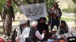 FILE: Taliban fighters militia talk with villagers on the outskirts of Gardez, the capital of Paktia province in southwestern Afghanistan.