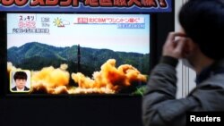 Мужчина в Японии смотрит телевизор, по которому показывают новость об испытании Северной Кореей баллистической ракеты. Токио, 29 ноября 2017 года.