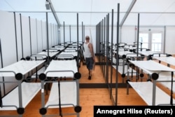 Чоловік розставлює ліжка в приміщенні аеропорту «Тегель», 24 березня 2022 рік