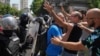 People in Belgrade react as Serbian police remove a street blockade on June 30. 