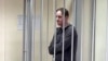 Jurnalistul american Evan Gershkovich, arestat sub acuzația de spionaj, stă în cușca de inculpat în timpul audierilor în care judecătorii ruși au decis extinderea detenției. 26 ianuarie 2024.