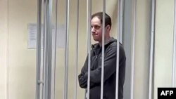 Jurnalistul american Evan Gershkovich, arestat sub acuzația de spionaj, stă în cușca de inculpat în timpul audierilor în care judecătorii ruși au decis extinderea detenției. 26 ianuarie 2024.