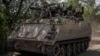 Ukrainian soldiers ride an armored personnel carrier near the frontline city of Bakhmut. 