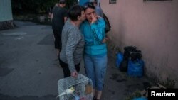 Local residents react after their evacuation from a flooded area in Kherson after the Nova Kakhovka Dam was breached on June 6.