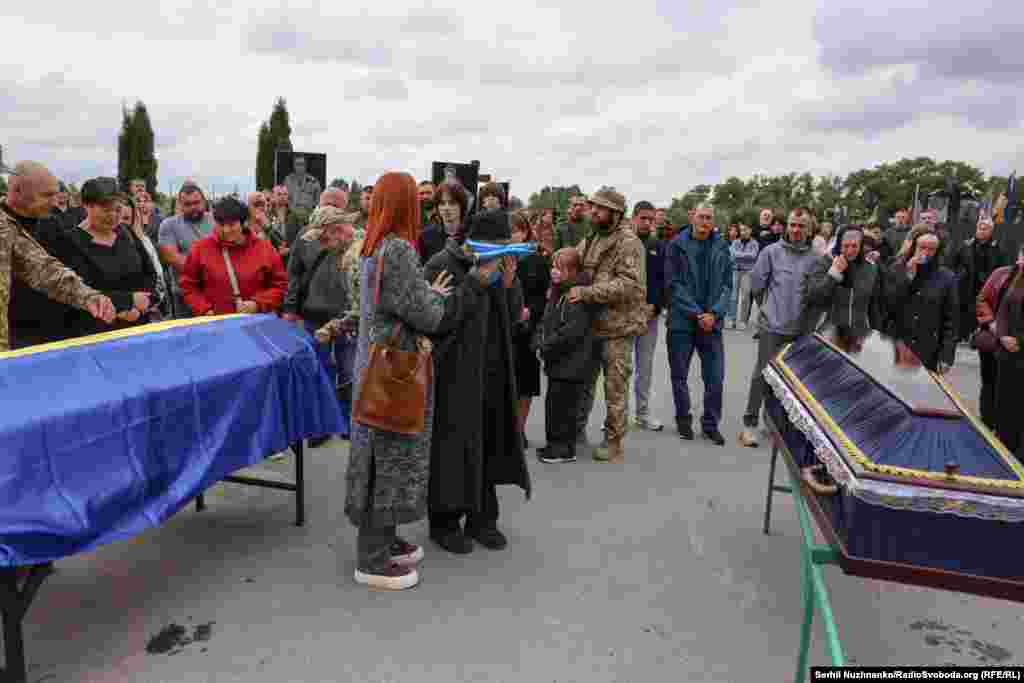 Мама Віталія Бондаренка плаче над прапором України, яким була вкрита труна її сина