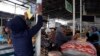 A supporter of the Islamic Renaissance Party of Tajikistan (IRPT) pastes a campaign poster at a market in the capital, Dushanbe, in 2015, the year it was banned in the country and labeled a terrorist group.