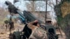 A Russian soldier aims a D-30 howitzer toward Ukrainian positions in the border area of Kursk region, Russia, in early December.