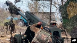 A Russian soldier aims a D-30 howitzer toward Ukrainian positions in the border area of Kursk region, Russia, in early December.