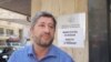 Христо Иванов пред министерството на икономиката. Зад гърба му се вижда надписът Министерство на Пеевски" и "Ministry of 6I6Inomy"