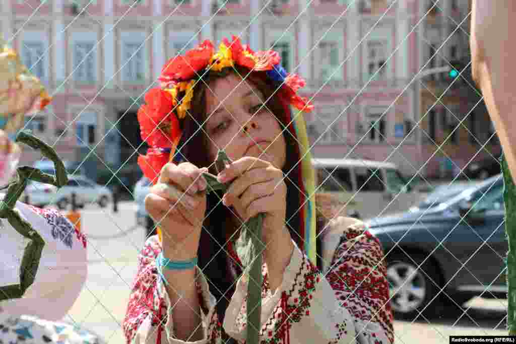 Відвідувачі ярмарку плетуть маскувальну сітку