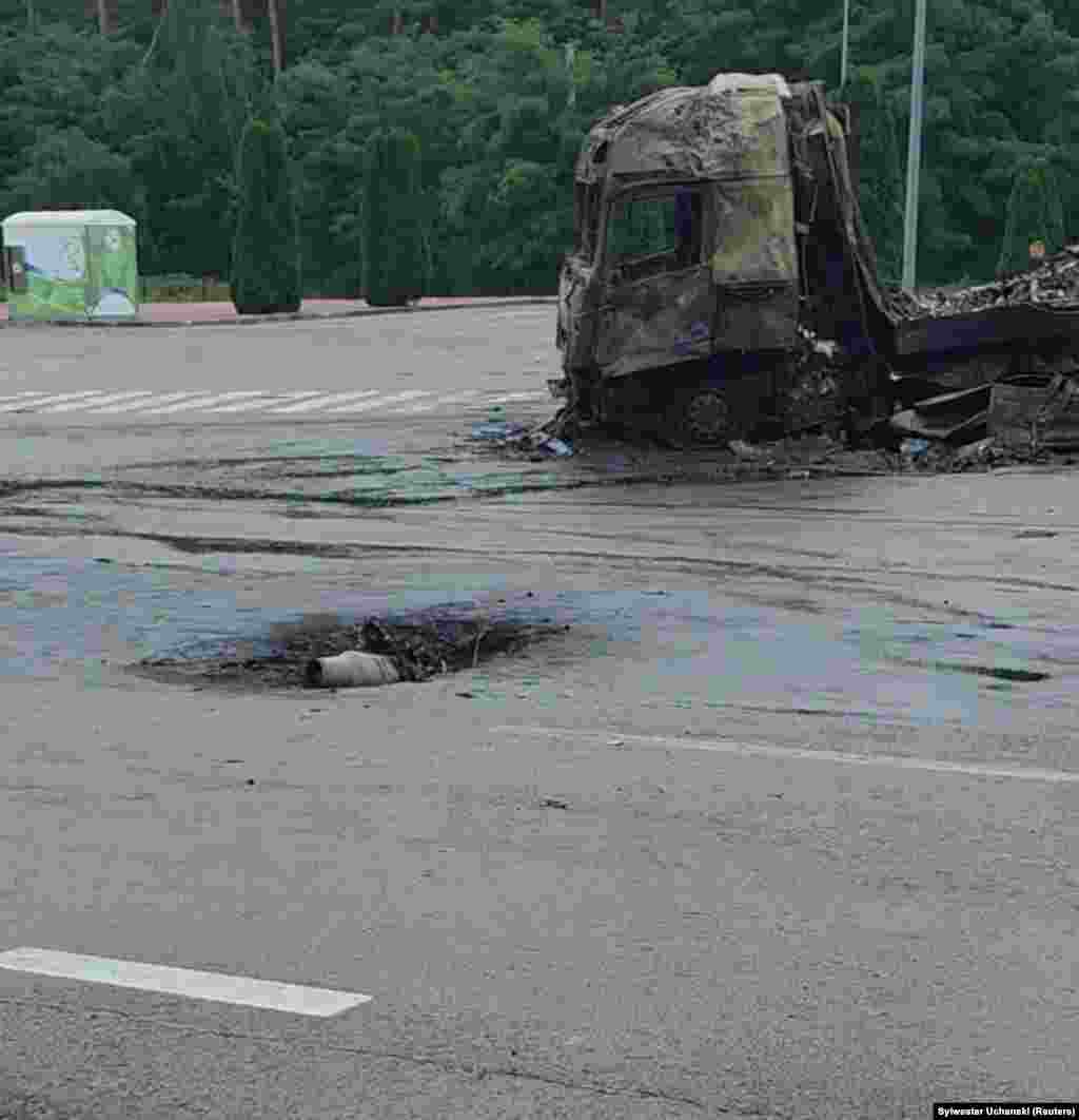 A burned-out truck lies near the crater left by a drone that exploded 800 meters from Ukraine's Yahodyn border crossing with Poland on September 13. The strike came on the same day that another attack drone struck a Warsaw-bound passenger train at a Ukrainian station nearby.