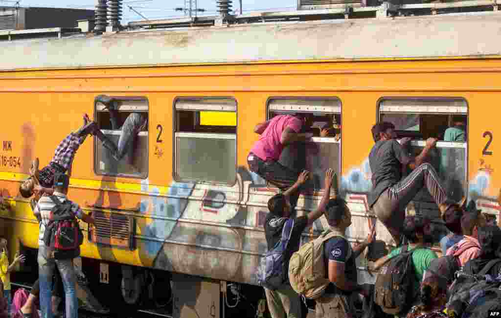 Migrants try to board a train to Serbia in the town of Gevgelija, on the Macedonian-Greek border, on July 30. (AFP/Robert Atanasovski)