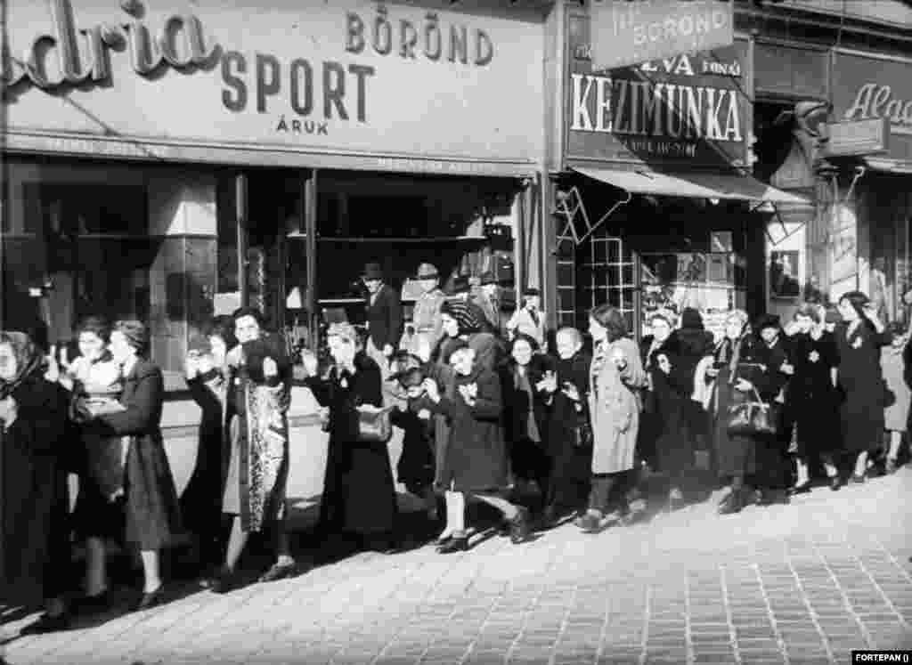 1944. október 17-én nyilasok magyar zsidók ezreit meneteltették feltartott kézzel Budapest utcáin. Ez a kép a Rákóczi út 32. számnál készült