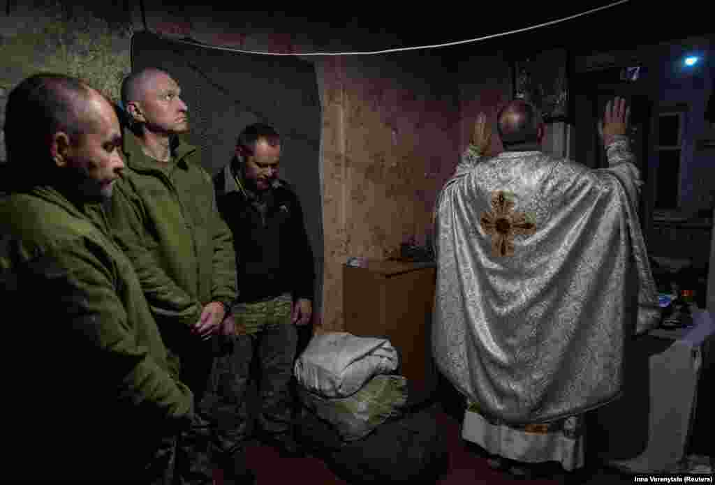 A military chaplain conducts an Orthodox service for new recruits of the 24th Separate Mechanized Brigade of the Ukrainian armed forces before their first combat mission, amid Russia&#39;s attack on Ukraine, near the town of Chasiv Yar in the Donetsk region.