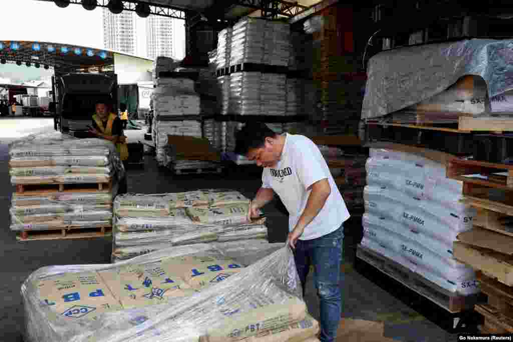 A worker with bags of plastic pellets at a warehouse in China's Guangdong Province on April 1. Plastic products are made from fossil fuels and experts warn the price of the material is set to rise behind the surge in oil prices.