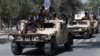 Armed Taliban fighters parade atop humvee vehicles in Kabul in 2022.