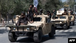 Naoružani talibanski borci u paradi na vozilima, Kabul 2022. godine.