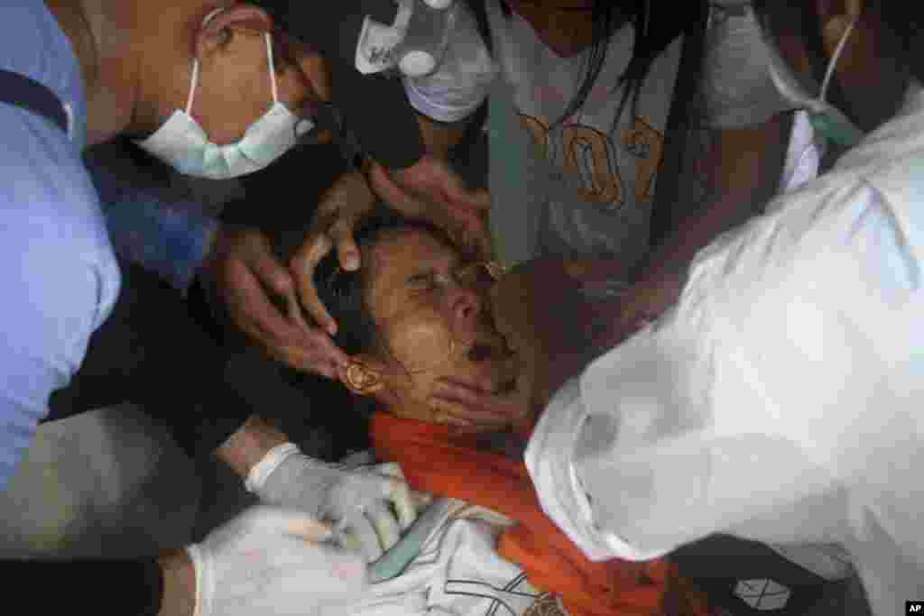A woman is treated by nurse as she got tear gas during an anti-coup protest in Yangon, Myanmar, Tuesday, March 2, 2021.