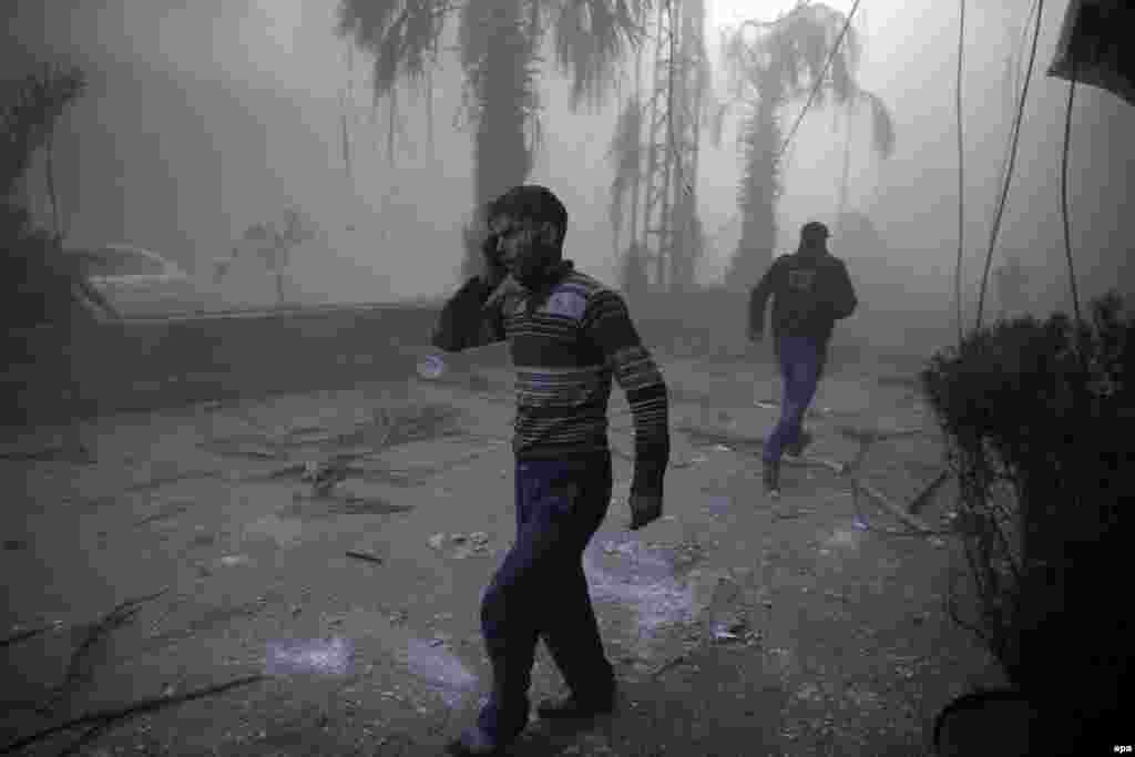 First Prize Stories in the Spot News Category was won by Syrian photographer Sameer Al-Doumy for his dramatic images of the the aftermath of air strikes in Syria. This photo from the series shows a wounded man walking out of a dust cloud following reported air strikes in the town of Hamouria, Syria. (December 9, 2015)