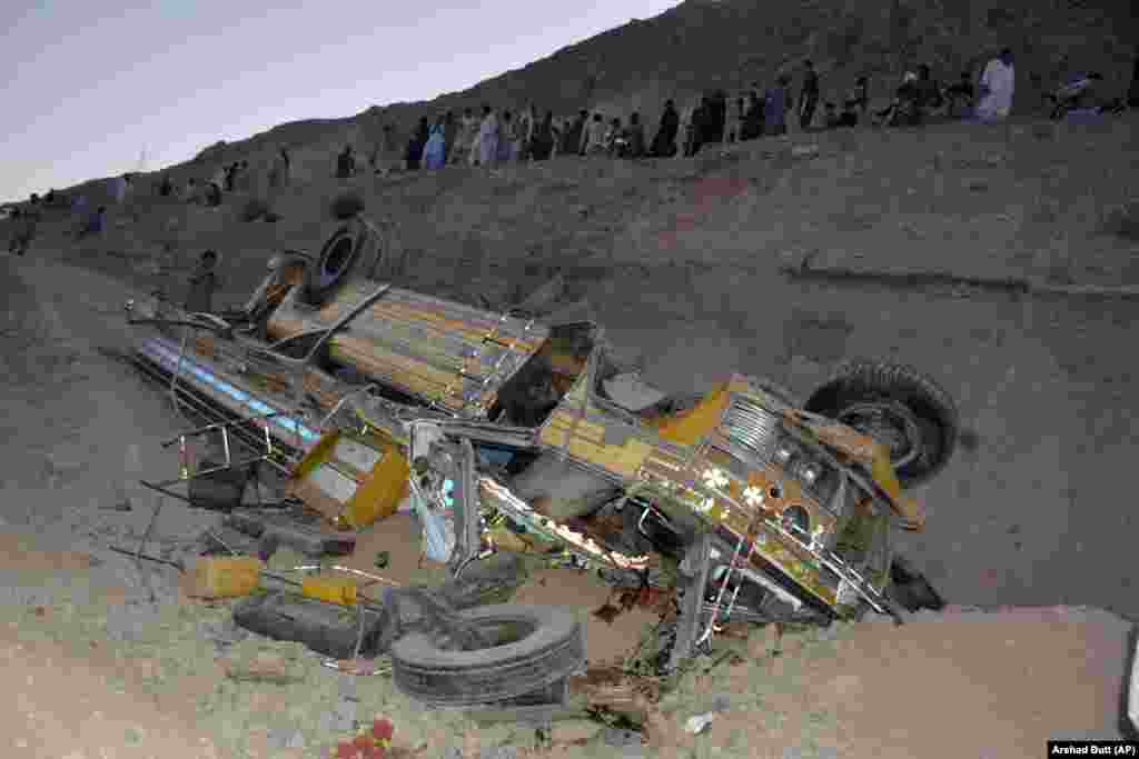 Locals gather near the wreckage of a bus that fell into a ravine near Quetta, the capital of Pakistan&#39;s Balochistan Province.&nbsp;