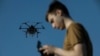 Un militar ucrainean controlează o dronă în timpul unui zbor, într-o locație secretă din regiunea Harkov, Ucraina, aprilie 2025.