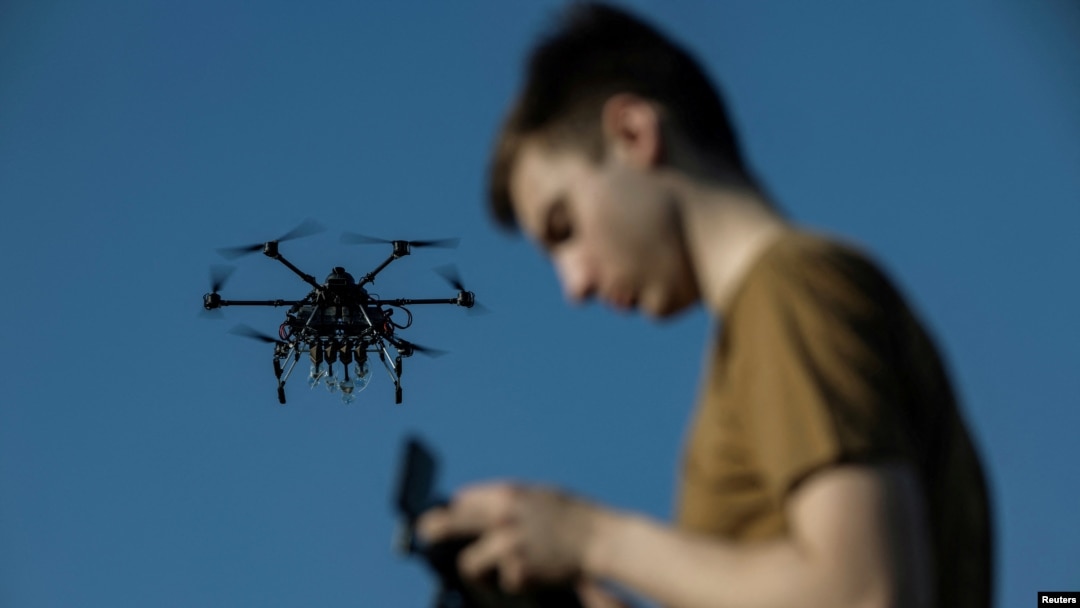 Un militar ucrainean controlează o dronă în timpul unui zbor, într-o locație secretă din regiunea Harkov, Ucraina, aprilie 2025.
